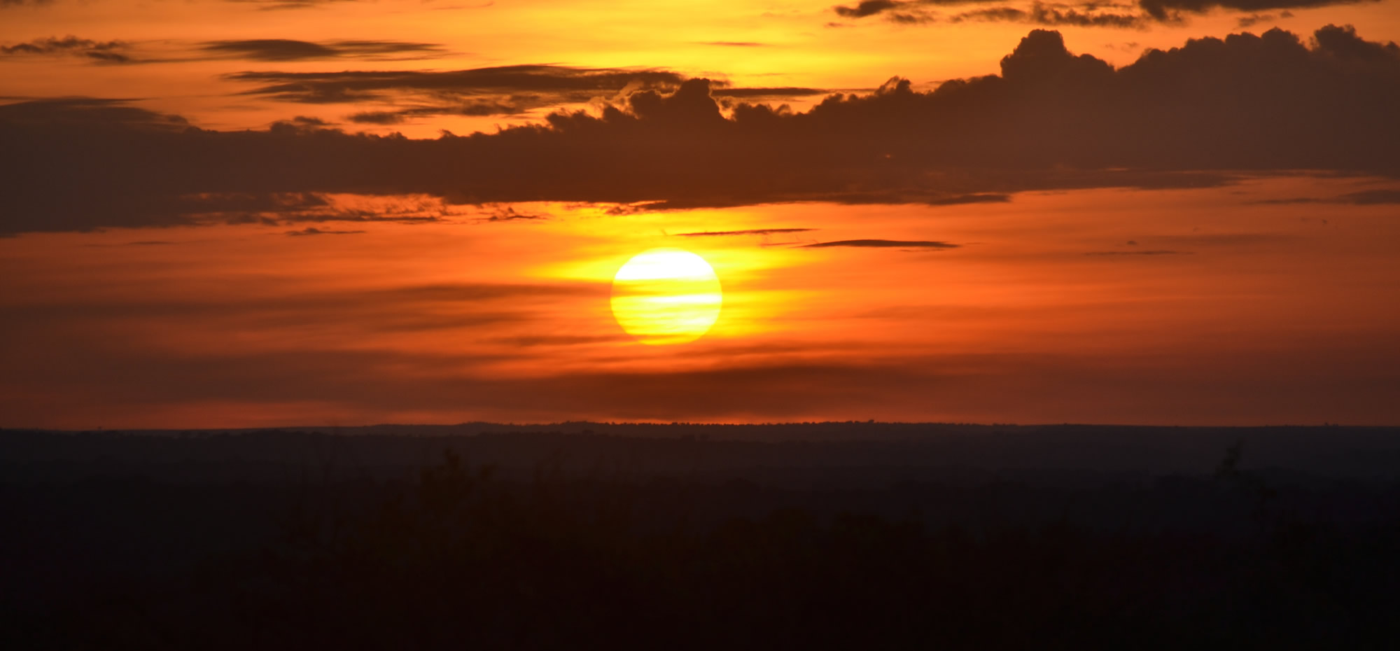 African sunset showing dark horizon and minimal clouds